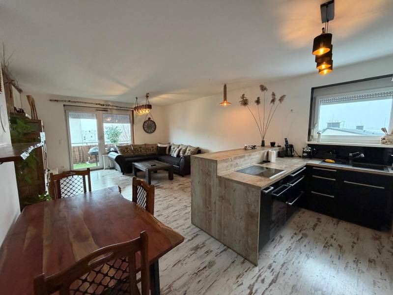 Zariadený 3 izbový byt s balkónom v Kittsee  - Obývacia izba s kuchyňou v 3-izbovom byte, podlaha s dreveným dekorom.