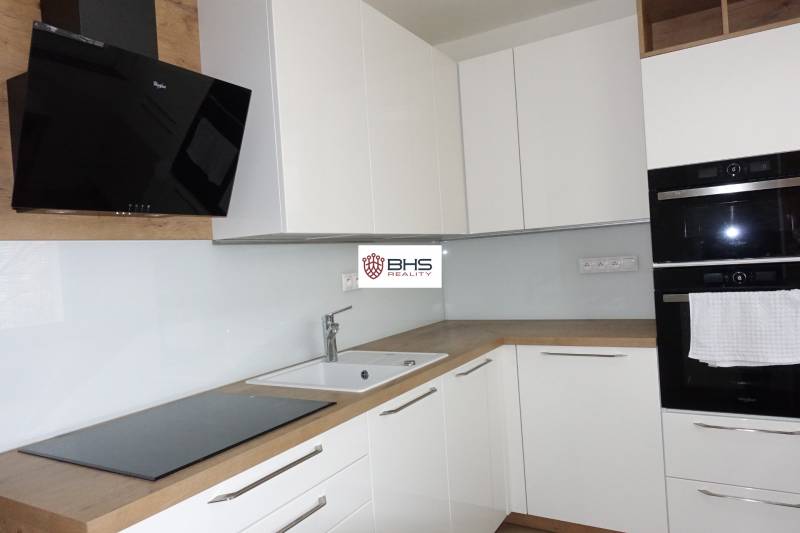 PRENÁJOM –  1 izba (príp. 2 izby) v 3-izb. byte, Gwerkovej ul., BA V - Kuchyňa s bielymi skrinkami a spotrebičmi, doplnená podlahou s dreveným dekorom v 3-izbovom byte.