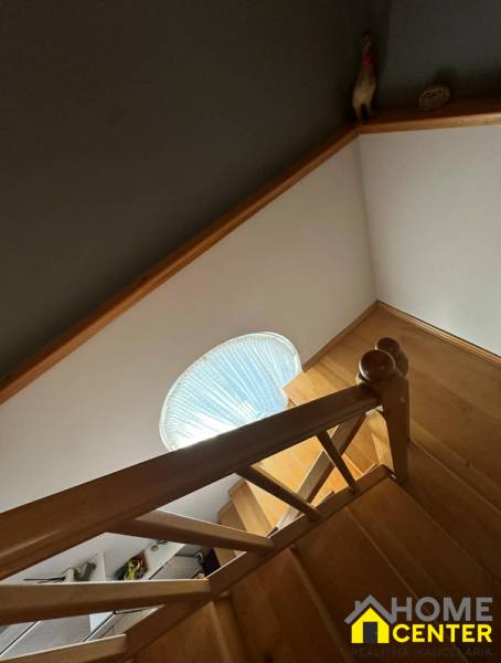 PREDAJ : RODINNÝ DOM, KOMÁRNO - Schodisko s dreveným dekorom v rodinnom dome so schodiskovým zábradlím a kruhovým oknom.