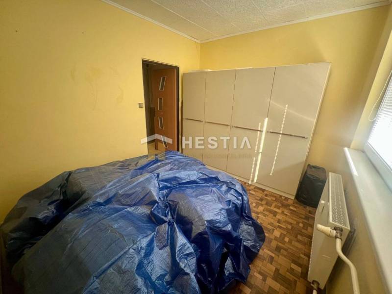 TOP 3 izbový byt v Moravskom Lieskovom s garážou a predzáhradkou - Izba so skriňou, radiátorom a zakrytým nábytkom v 3-izbovom byte.