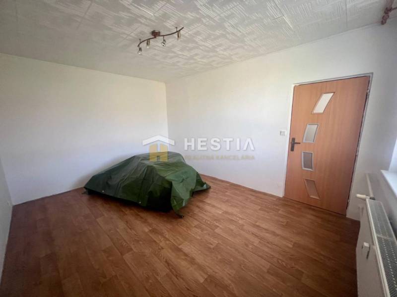 TOP 3 izbový byt v Moravskom Lieskovom s garážou a predzáhradkou - Izba v 3-izbovom byte s podlahou, radiátorom, dverami a jednoduchým osvetlením.