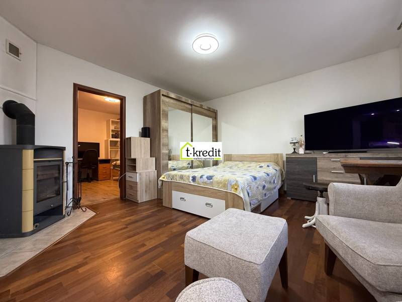 PREDAJ - 2i BYT - ZLATÉ MORAVCE - Interiér izby s podlahou s dreveným dekorom a krbom v 2-izbovom byte.