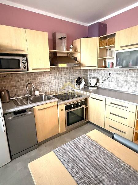 Prenájom 3 izbový byt, Švabinského ulica, Bratislava V. Petržalka - Kuchyňa v 3-izbovom byte s dreveným dekorom skriniek, sušičkou a rúrou.