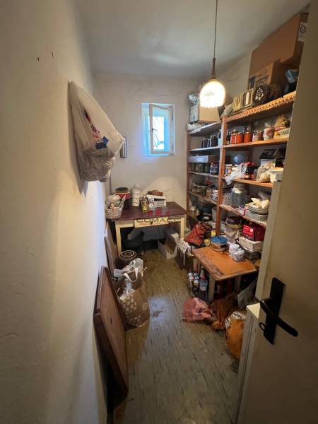 RD Drahovce ZĽAVA !!! - Úložný priestor v rodinnom dome s regálmi plnými rôznych predmetov a otvoreným oknom.