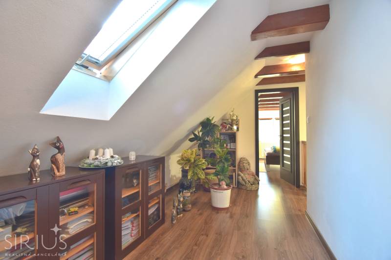 LIMBACH, 176 m2 –  kompletne zrekonštruovaný 5-i rodinný dom - Podkrovná chodba v rodinnom dome so šikmým stropom v Limbachu, vybavená poličkami a rastlinami.