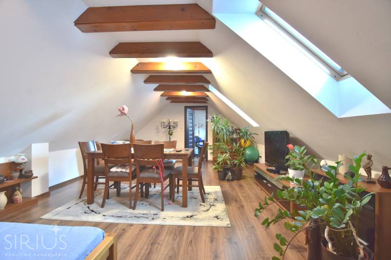 LIMBACH, 176 m2 –  kompletne zrekonštruovaný 5-i rodinný dom - Podkrovný interiér s jedálenským stolom, drevenými trámami, kvety a svetlíkové okná na ulici Limbach.