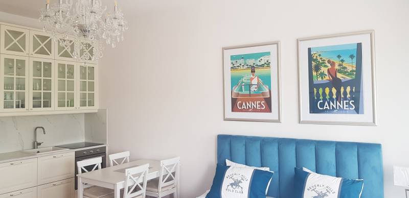 Nádherný, staromestský, 1-izb. byt v centre s výhľadom na Dunaj - Interiér 1-izbového bytu s kuchyňou, lustrom a obrazmi nad modrou posteľou.