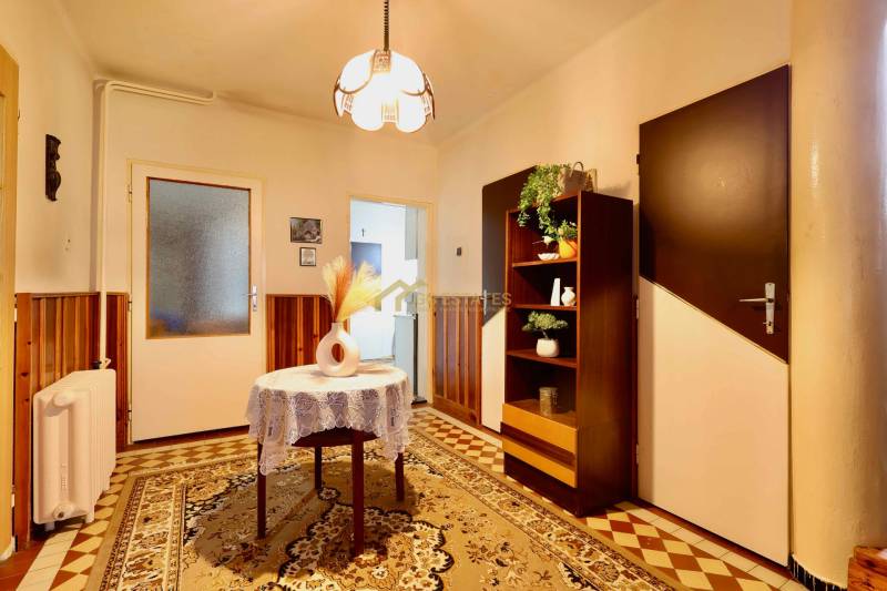 RD v jednej z najžiadanejších lokalít Michaloviec – pod Hrádkom - Interiér rodinného domu s kobercovou podlahou, v pozadí skrinka a osvetlenie.