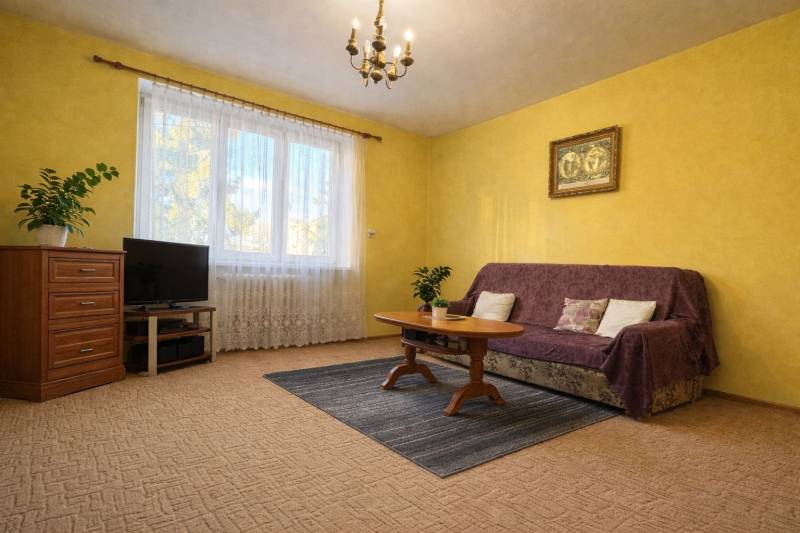 REZERVONY - 2 izbový tehlový byt na Novej Dubnici, 60  - Obývacia izba v 2-izbovom byte, so žltými stenami, kobercom a nábytkom.