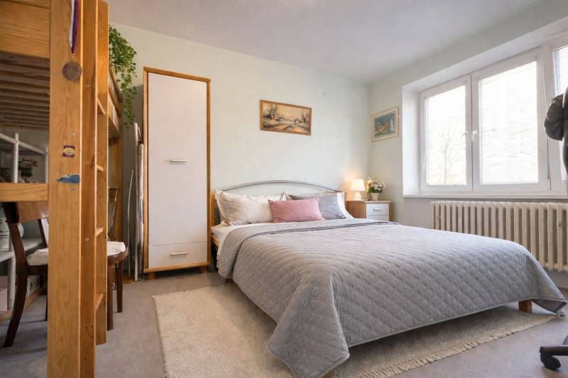 REZERVONY - 2 izbový tehlový byt na Novej Dubnici, 60  - Spálňa v 2-izbovom byte s veľkou posteľou, dekoráciami a naturalistickým osvetlením.