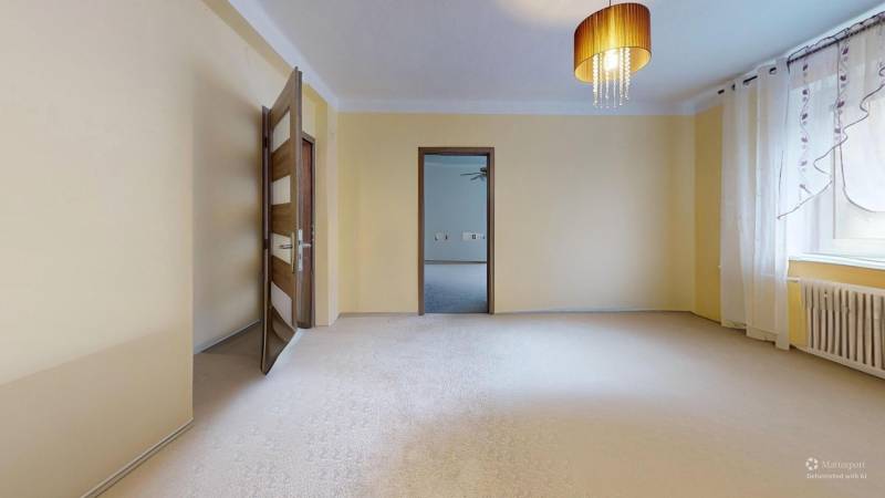 Prerobený rodinný dom na veľkom tichom pozemku v obci Pruské   - Svetlá izba v rodinnom dome so záclonami, lustrom a otvorenými dverami.