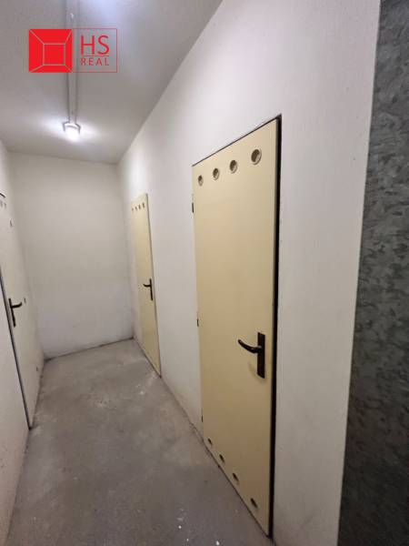 Predaj 3 izb. bytu s balkónom v NZ - Chodba s viacerými dverami v priestore 3-izbového bytu, svetlé steny, betónová podlaha.