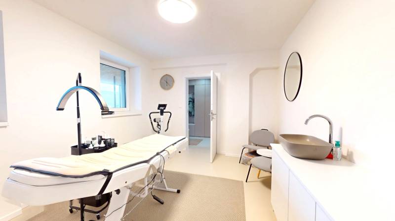 Novozariadený rodinný dom s veľkými spálňami i šatníkom pri Trenčíne   - Interiér rodinného domu s masážnym stolom, umývadlo, zrkadlo a stoličky.