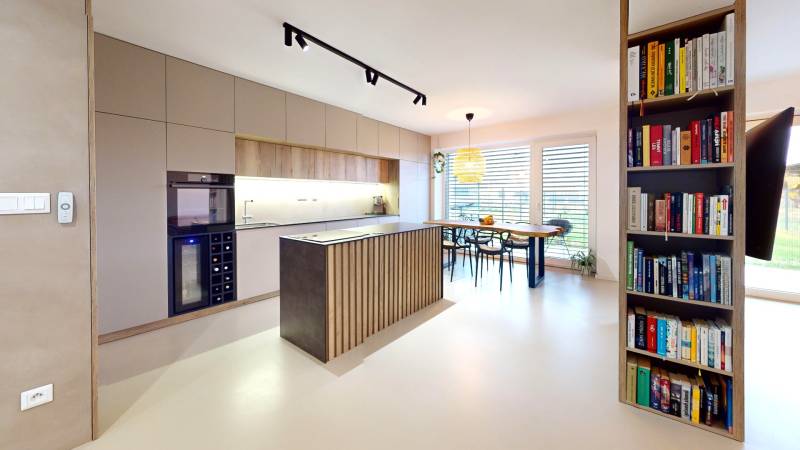 Novozariadený rodinný dom s veľkými spálňami i šatníkom pri Trenčíne   - Otvorná kuchyňa s jedálenským stolom a knihovničkou v rodinnom dome.