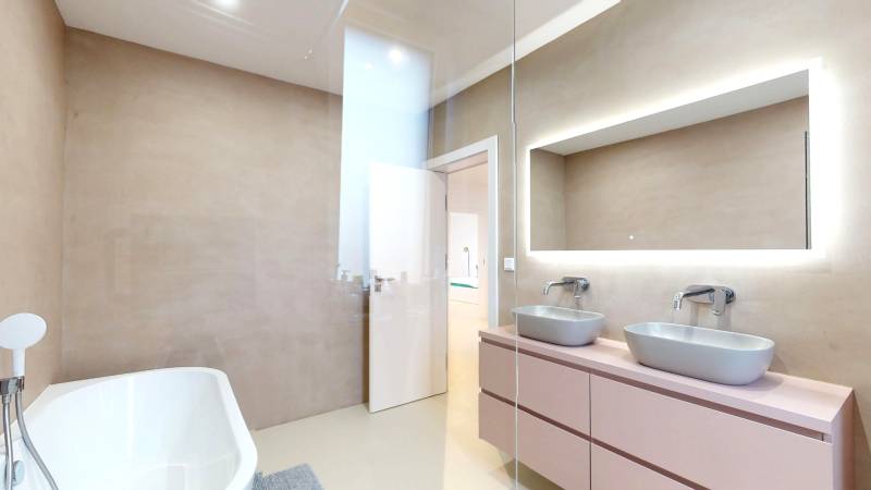 Novozariadený rodinný dom s veľkými spálňami i šatníkom pri Trenčíne   - Kúpeľňa s vaňou, dvomi umývadlami a zrkadlom v rodinnom dome.