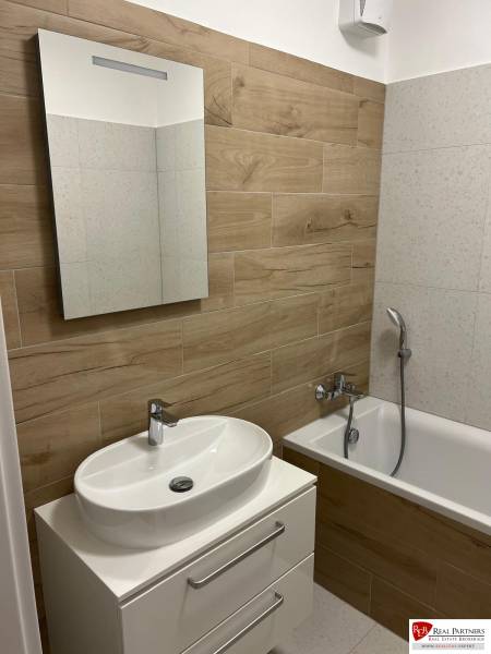 - PRENÁJOM 2-IZ. BYTU S PARKOVACÍM MIESTOM – MILOSLAVOV - Kúpeľňa v 2-izbovom byte s podlahou s dreveným dekorom a vaňou.