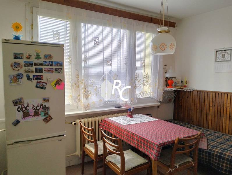 Veľký 2-izbový byt, Martin - Sever - REZERVOVANÉ - Kuchyňa v 2-izbovom byte s jedálenským stolom, stoličkami a chladničkou s magnetkami.