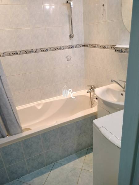 2 izbový byt na Severe - Kúpeľňa v 2-izbovom byte s vaňou a svetlými obkladmi.