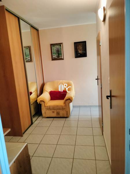 2 izbový byt na Severe - Kreslo pri vstupných dverách s dlaždicovou podlahou v 2-izbovom byte, zrkadlová skriňa.