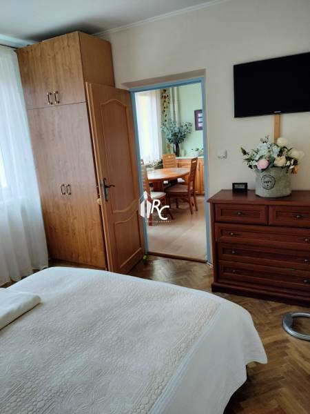 2 izbový byt na Severe - Spálňa so vstavanou skriňou v 2-izbovom byte, podlaha s dreveným dekorom, dvere vedú do kuchyne.