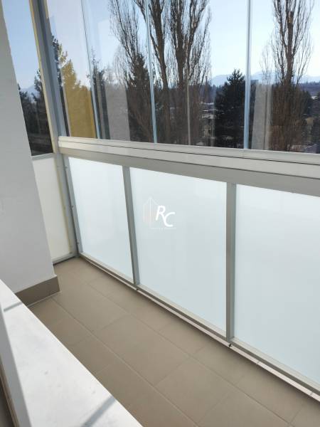 2 izbový byt na Severe - Zasklený balkón v 2-izbovom byte s výhľadom na stromy a hory.