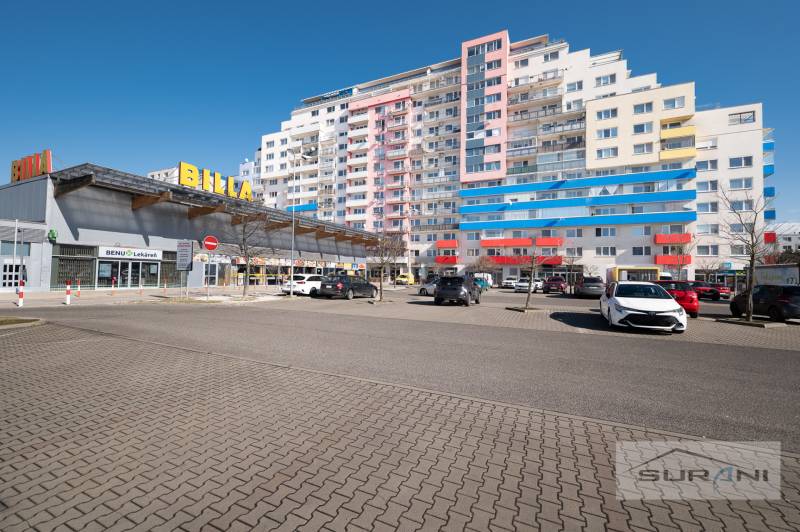 Nové v ponuke | 3-izbový byt 91 m² | 2× balkón | parkovanie | RUSTICA  - Billa na Saratovskej ulici, Bratislava - Dúbravka, vedľa bytového domu s parkoviskom.