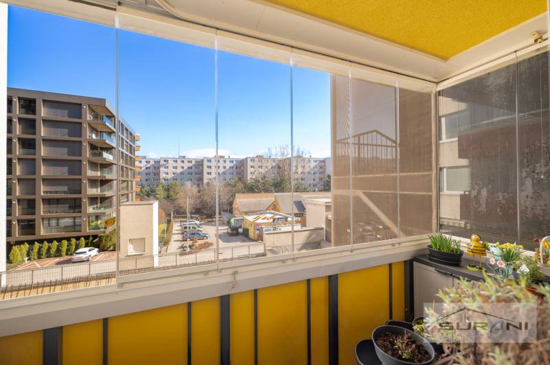 Nové v ponuke | 3-izbový byt 91 m² | 2× balkón | parkovanie | RUSTICA  - Zasklená lodžia s výhľadom na moderné bytovky, 3-izbový byt, Dúbravka, Bratislava.