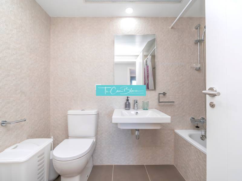 Luxusný byt  Alicante, 112m2, bazén, 2 garáže, posilňovňa - Kúpeľňa v 2-izbovom byte s toaletou, umývadlom, vaňou a béžovým obkladom.