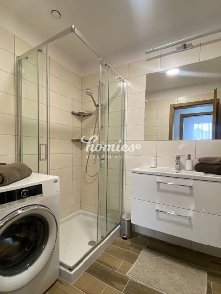 PRENÁJOM luxusný 2 izbový byt v centre mesta Nitra, parkovanie - Kúpeľňa v 2-izbovom byte s práčkou, sprchovacím kútom a podlahou s dreveným dekorom.