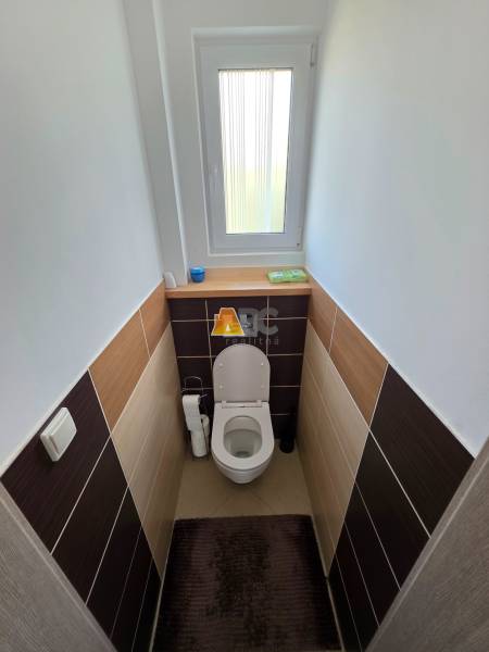 Zabehnutá novostavba: Komfort domu, pokoj vidieka a na skok do BB a ZV - Toaleta v Rodinnom dome s oknom a keramickými obkladačkami, podlaha s dekorom.