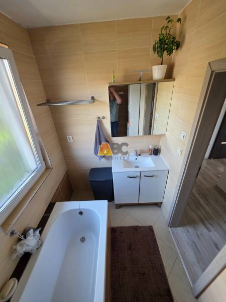 Zabehnutá novostavba: Komfort domu, pokoj vidieka a na skok do BB a ZV - Kúpeľňa v rodinnom dome s vaňou, skrinkou pod umývadlom a oknom so svetlom.