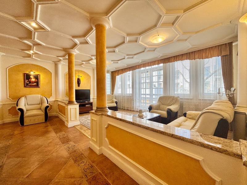 I PRENÁJOM - Priestranný 4 izbový byt na Zámockej ulici, BA - Štýlová obývačka v 4-izbovom byte s koženými sedačkami, stĺpmi a dekoratívnym podhľadom.