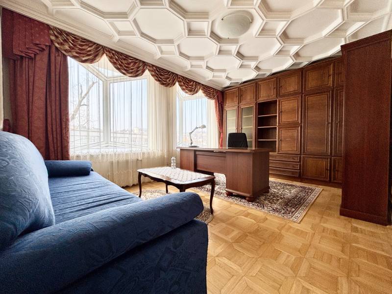 I PRENÁJOM - Priestranný 4 izbový byt na Zámockej ulici, BA - Izba v 4-izbovom byte s pohodlným gaučom, pracovným stolom a podlahou s dreveným dekorom.