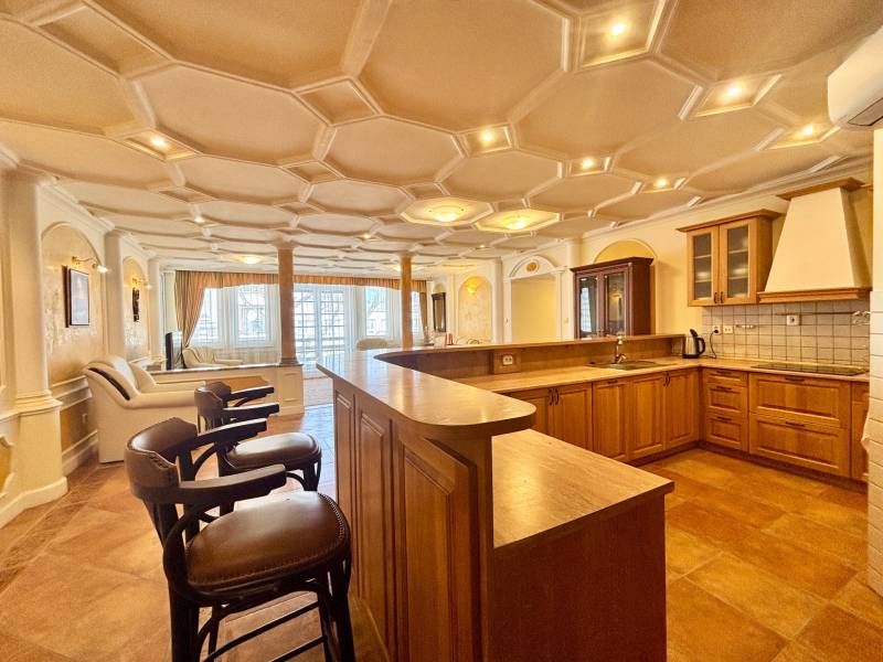 I PRENÁJOM - Priestranný 4 izbový byt na Zámockej ulici, BA - Kuchyňa v 4-izbovom byte s podlahou s dreveným dekorom a barovými stoličkami.