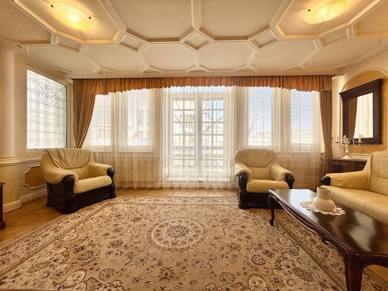 I PRENÁJOM - Priestranný 4 izbový byt na Zámockej ulici, BA - Obývacia izba so svetlými kreslami, kobercom a podlahou s dreveným dekorom v 4-izbovom byte.