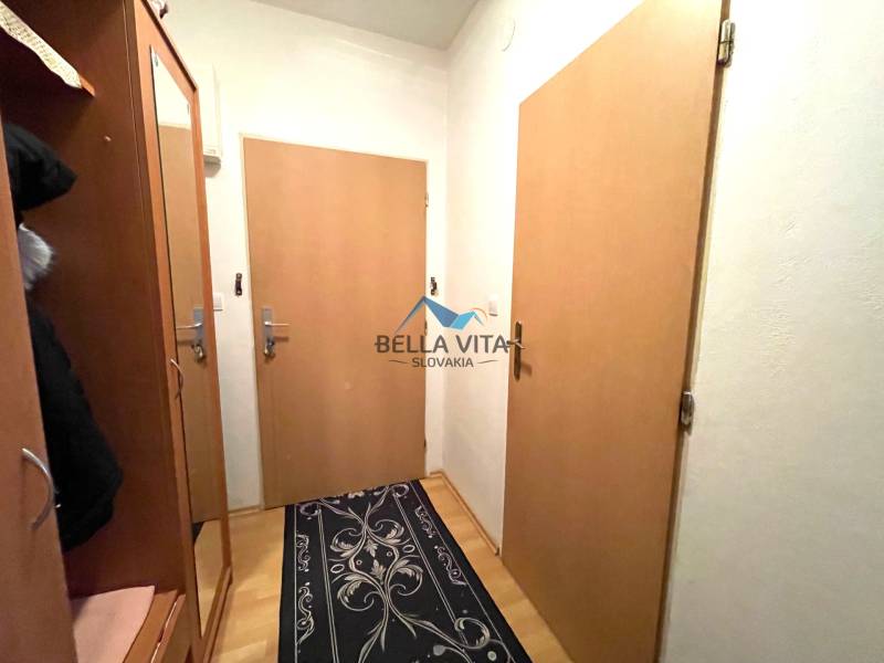 EXKLUZÍVNY PREDAJ - 1 izbový byt, Vodárenská ulica Galanta - Chodba v 1-izbovom byte s nábytkom, dverami a podlahou s dreveným dekorom.