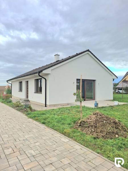 | 4 izbový rodinný dom s krbom a terasov | Slnečná | Ružindol - Rodinný dom na Slnečnej v Ružindole s bielou fasádou a zámkovou dlažbou.