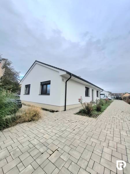 | 4 izbový rodinný dom s krbom a terasov | Slnečná | Ružindol - Rodinný dom na Slnečnej ulici v Ružindole s bielou fasádou a dlažbou.