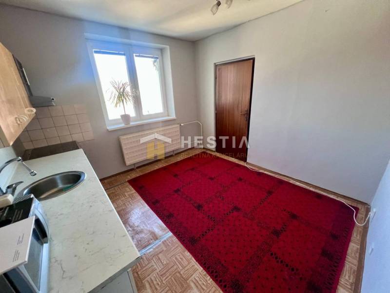 NOVINKA 3 izbový byt v Brezovej pod Bradlom s krásnym výhľadom - Kuchyňa 3-izbového bytu s kobercom, podlahou s dreveným dekorom a jednoduchým zariadením.