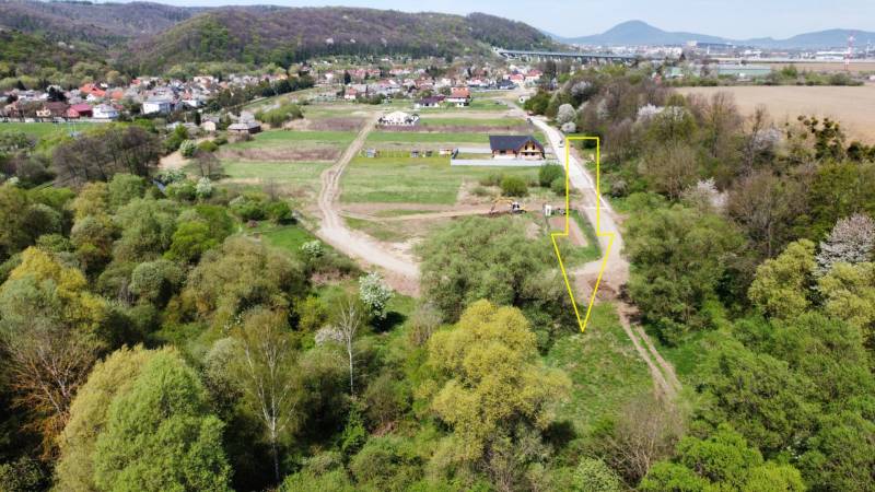 NA PREDAJ STAVEBNÝ POZEMOK  V DOSAHU MHD PREŠOV - HANISKA - Letecký pohľad na pozemky v Haniske obklopené zeleňou a cestnou infraštruktúrou.