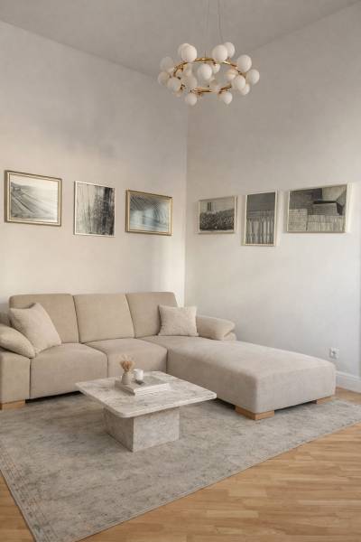 NA PRENÁJOM,Nadštandardný 3-izbový tehlový byt s parkingom,Mlynská ul. - Obývačka v 3-izbovom byte s béžovou sedačkou, stolíkom, obrazmi a podlahou s dreveným dekorom.