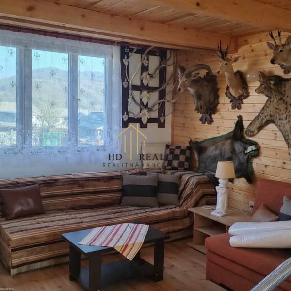 Predaj ,drevená chatka v obci Kráľovce Krnišov - Interiér chaty s trofejami, dreveným obložením a podlahou s dreveným dekorom.