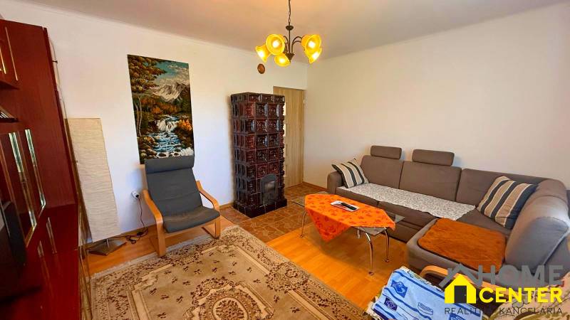 ZĽAVA!! NA PREDAJ RODINNÝ DOM V ZEMIANSKEJ OLČI – PO REKONŠTRUKCII - Obývačka v rodinnom dome s pohovkou, kreslom, kachľovou pecou a obrazom prírody.