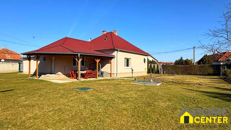 ZĽAVA!! NA PREDAJ RODINNÝ DOM V ZEMIANSKEJ OLČI – PO REKONŠTRUKCII - Rodinný dom v Zemianskej Olči s červenou strechou a dreveným prístreškom, trávnatá záhrada.