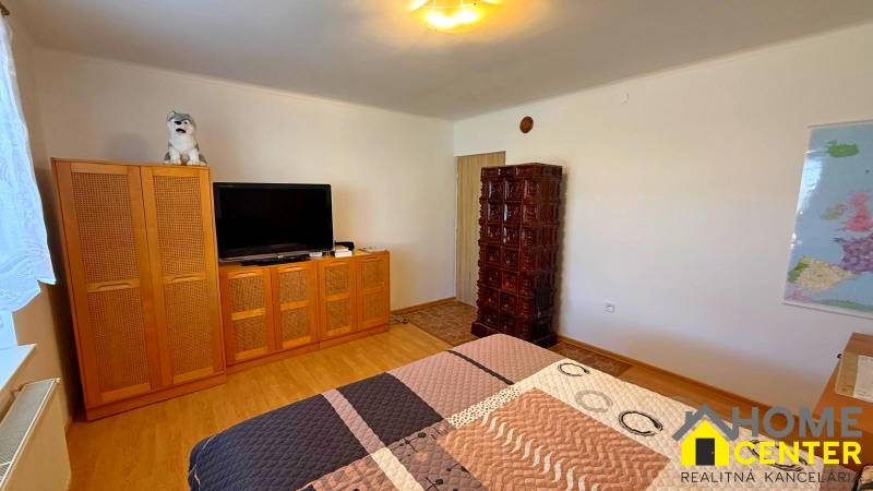 ZĽAVA!! NA PREDAJ RODINNÝ DOM V ZEMIANSKEJ OLČI – PO REKONŠTRUKCII - Izba v rodinnom dome s televíziou, skriňou, kachľovou pecou a podlahou s dreveným dekorom.