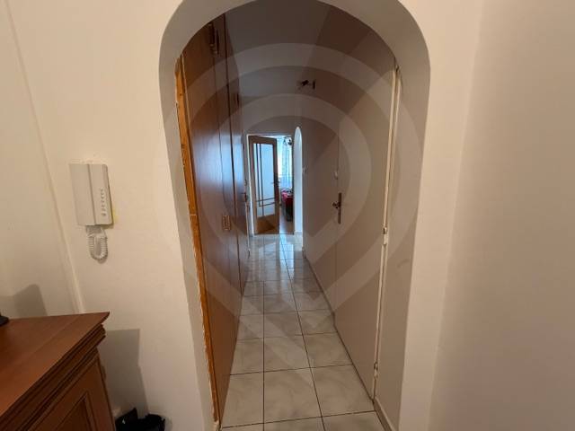 Predaj 3.izbového bytu v Ružinove v obkolesené borovicového lesíka - Chodba so svetlou dlažbou, oblúkovým priechodom a skriňou v 3-izbovom byte.