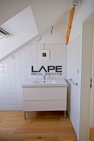 Rodinný dom s veľkou záhradou - Ružinov  - Kúpeľňa rodinného domu s umývadlom a podlahou s dreveným dekorom.