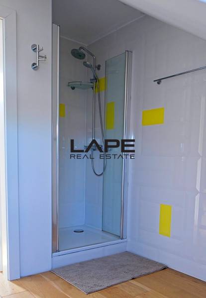 Rodinný dom s veľkou záhradou - Ružinov  - Sprchovací kút s viacfarebnou stenou a podlahou s dreveným dekorom v rodinnom dome.