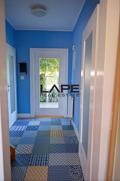 Rodinný dom s veľkou záhradou - Ružinov  - Chodba v rodinnom dome s modrými stenami a mozaikovou podlahou.