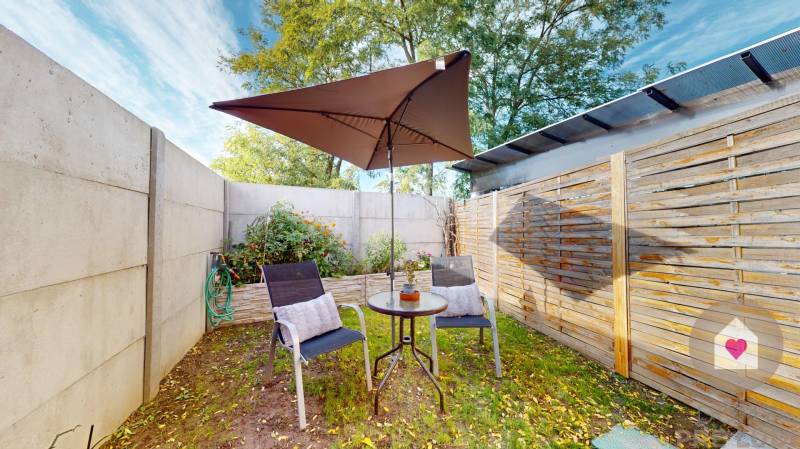 DOBROHOŠŤ- Prenájom  3i zariadeného bytu s predzáhradkou a parkingom - Záhrada 3-izbového bytu v Dobrohošti so stolom, stoličkami a slnečníkom.